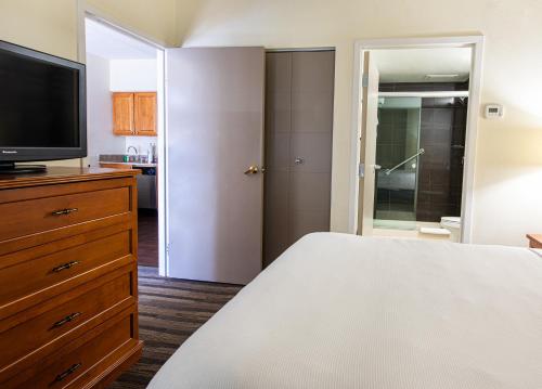 a bedroom with a bed and a flat screen tv at Hyatt House Chicago Schaumburg in Schaumburg
