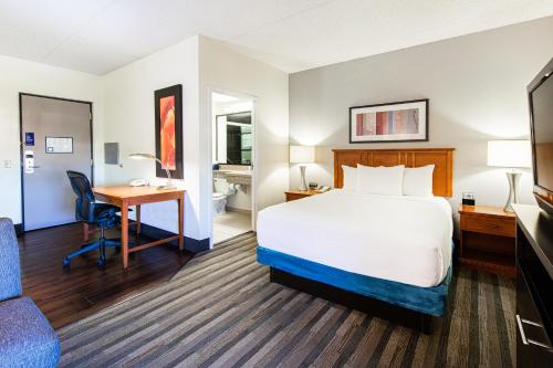 a hotel room with a bed and a desk at Hyatt House Chicago Schaumburg in Schaumburg