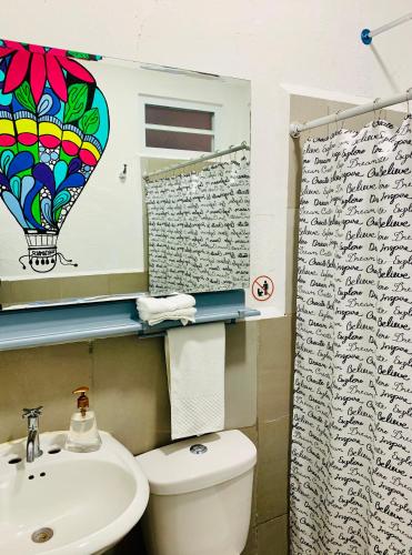 a bathroom with a toilet and a sink and a shower curtain at Hotel y Arte Antigua by Amazing Guatemala Travel in Antigua Guatemala
