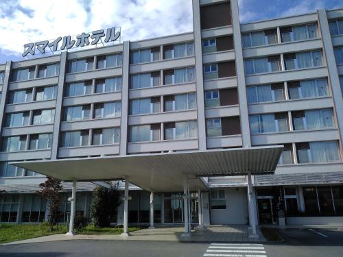 Nishigo的住宿－Smile Hotel Shirakawa，一座酒店大楼,上面有标志