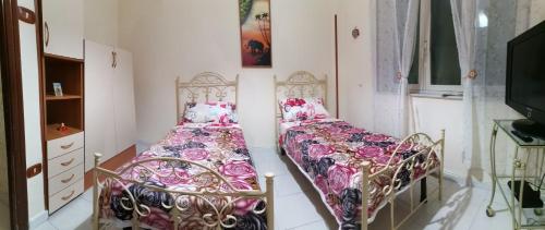 sypialnia z dwoma łóżkami i telewizorem w obiekcie A casa di Italia w mieście Napoli