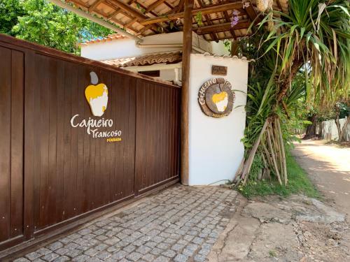 an entrance to a fence with an apple sign on it at Pousada Cajueiro Trancoso in Trancoso