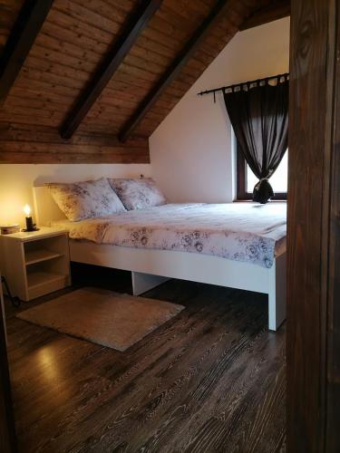 a bedroom with a large bed and a window at Holiday Home Drinsko svitanje in Gornja Trešnjica