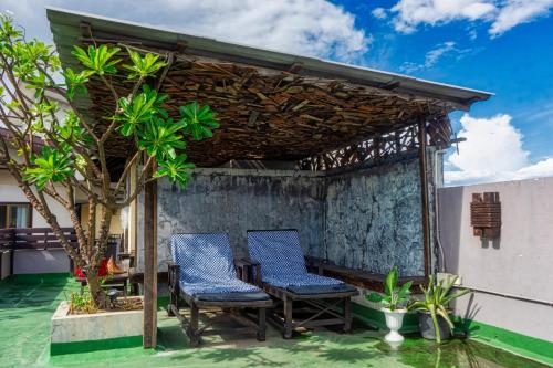 two chairs and a table under a pergola on a patio at Ban Kong Rao Guesthouse in Chiang Mai