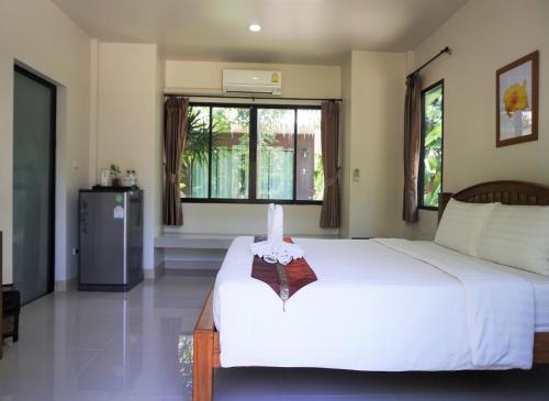 a bedroom with a large white bed and a window at Papa's Home And Rabbit Café in Ban Mai