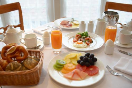 弗罗伊登施塔特Das Palmenwald Schwarzwaldhof, BW Signature Collection的桌子上摆满了早餐食品和橙汁