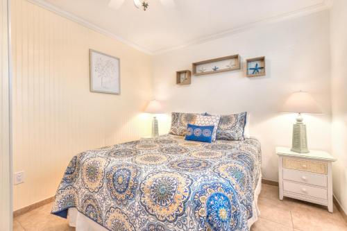 a bedroom with a bed and a nightstand and two lamps at Tropic Terrace #51 - Beachfront Rental condo in St. Pete Beach