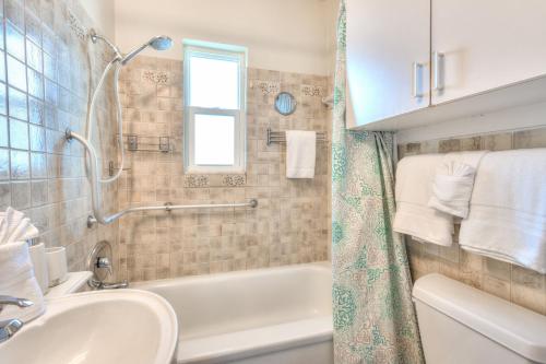 a bathroom with a white tub and a sink at Tropic Terrace #51 - Beachfront Rental condo in St. Pete Beach