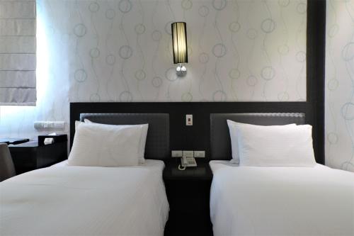 two beds sitting next to each other in a room at J-HOTEL in Kaohsiung