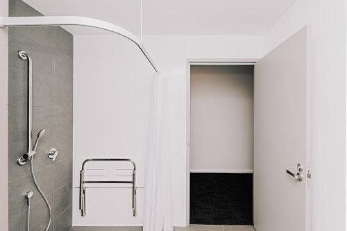 a bathroom with a shower with a chair in it at Toms Court Hotel in Adelaide