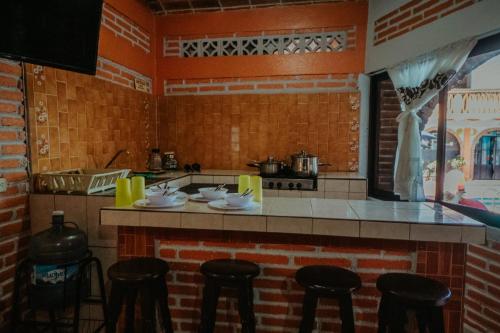 cocina con encimera con taburetes y fogones en Bungalows Flamingos en Rincón de Guayabitos
