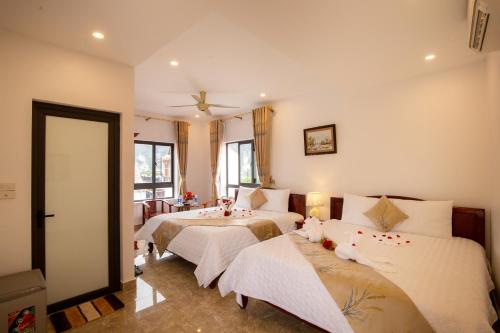 a bedroom with three beds with white sheets at Lys Homestay in Ninh Binh