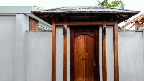 a wooden door with a roof on top of a building at Sampatti Villas in Seminyak