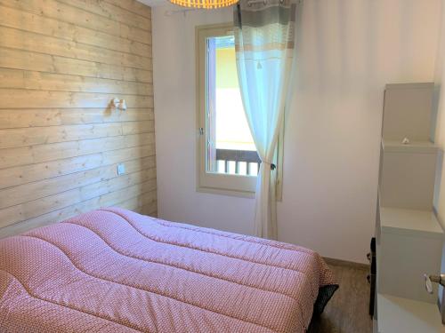 1 dormitorio con cama rosa y ventana en Le cozy du soulan - T2 bis - soda en Luchon