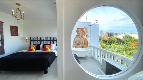 a bedroom with a bed and a window with a statue at Kunst in Bangkok