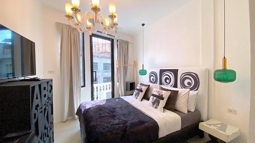 a bedroom with a bed and a chandelier at Kunst in Bangkok