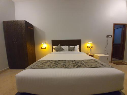 a bedroom with a large white bed and two lamps at Le Supreme Inn (the lap of luxury) in Puducherry