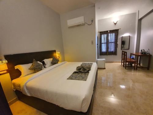 ein Schlafzimmer mit einem großen Bett in einem Zimmer in der Unterkunft Le Supreme Inn (the lap of luxury) in Puducherry