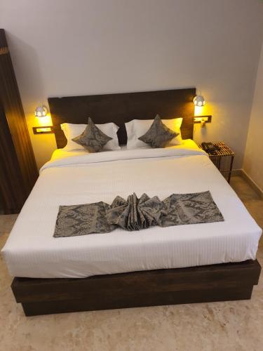 a bedroom with a large white bed with a black headboard at Le Supreme Inn (the lap of luxury) in Puducherry