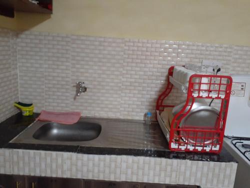 una cocina con fregadero y una cesta roja en la encimera en Royal studio in Kitengela, en Athi River
