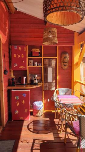 a room with a table and a kitchen with red walls at Poz Lagon in La Saline les Bains