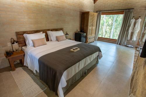 a bedroom with a large bed and a large window at Canto do Irere - Boutique Hotel in Atibaia