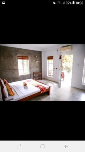 a bedroom with a large bed and two windows at La Perla Bentota in Bentota