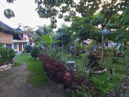 a garden with flowers and a stone wall at Gardenview Homestay Siargao in General Luna