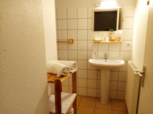 Baño pequeño con lavabo y toalla en Gîte - Auberge du Midi, en Saint-Antoine