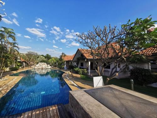 a swimming pool in front of a house at Two Fifty Nine Resort 259 Resort in Si Racha
