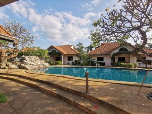 a swimming pool in front of a house at Two Fifty Nine Resort 259 Resort in Si Racha