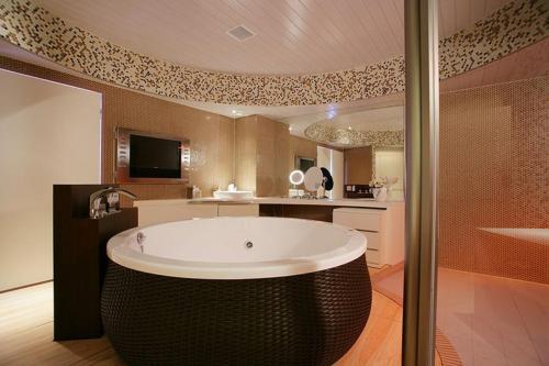 ein großes Bad mit einer großen Badewanne in der Mitte in der Unterkunft Hotel Oarai Seven Seas(Adult Only) in Oarai