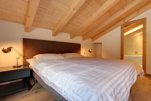 um quarto com uma grande cama branca e uma janela em Les Fleurettes em Le Châble