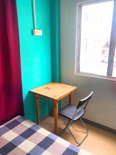 a wooden table and a chair in a room at Lavender@Guesthouse in Melaka