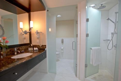 a bathroom with a shower and a sink and a toilet at InterContinental Abu Dhabi by IHG in Abu Dhabi