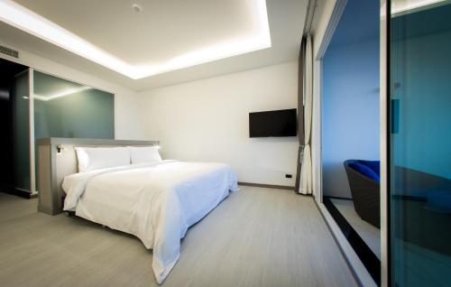 a bedroom with a white bed and a tv at Krabi Tipa Resort - SHA EXTRA PLUS in Ao Nang Beach