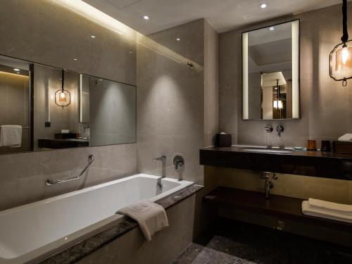 a bathroom with a bath tub and a sink at The Howard Prince Hotel Taichung in Taichung