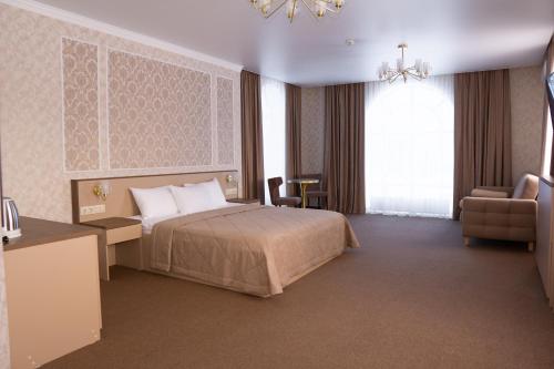エラブガにあるHotel and Restaurant Complex Shishkinのベッド、デスク、椅子が備わるホテルルームです。