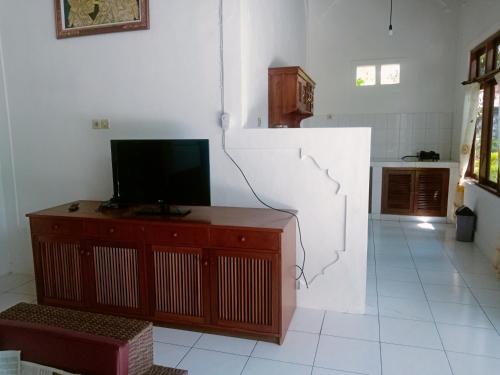 a living room with a television on a wooden dresser at Villa Mahalini Seminyak in Seminyak