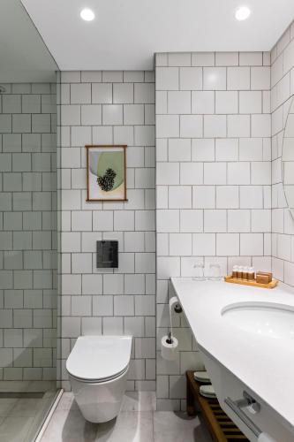 a white bathroom with a toilet and a tub at Ramat Rachel Resort in Jerusalem