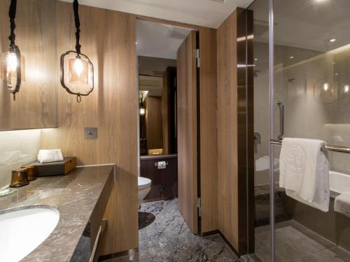 a bathroom with a sink and a toilet and a shower at The Howard Prince Hotel Taichung in Taichung