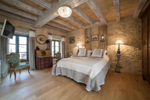 a bedroom with a bed and a tv in a room at Le Clos des Songes in Saint-Léon-sur-Vézère