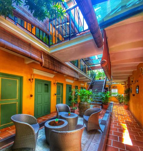 un patio avec des chaises et des tables dans un bâtiment dans l'établissement Yeng Keng Hotel, à George Town