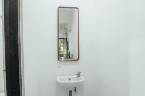 a bathroom with a sink and a mirror at Hotel Diana 2 in Kesiman