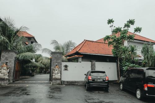 a car parked in a parking lot next to a house at Hotel Diana 2 in Kesiman
