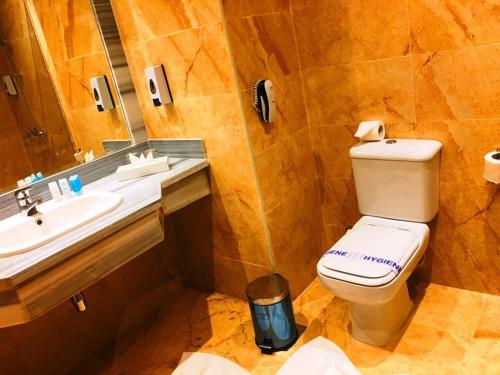 a bathroom with a toilet and a sink and a mirror at Hawaii Paradise Aqua Park Resort - Families and Couples Only in Hurghada