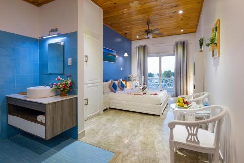 a blue and white bathroom with a couch and a room at Casa Maya Resort in ThÃ´n Báº£o An