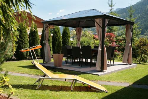 a gazebo with a table and chairs in a yard at Chalet Sabrina mit Außenpool im Sommer in Kaprun