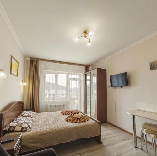a bedroom with a bed and a tv on the wall at Polyana Apart in Polyana