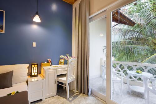 a bedroom with a desk and a balcony at Casa Maya Resort in ThÃ´n Báº£o An